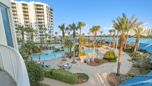 A resort with a swimming pool, palm trees, and a view of high-rise buildings. - 2317 Gorgeous 3 Bdrm ~ Lagoon Pool ~ Hot Tub ~ Restaurant ~ Bar ~ Book Sept 27 (Destin)