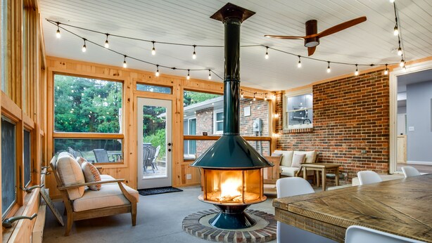 A cozy room with a wood-burning stove, a dining table, and comfortable seating.