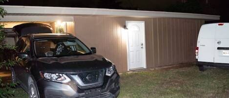 A black SUV parked in front of a house with a white door and a garage door.