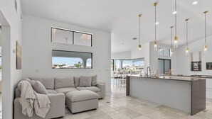 Una cocina moderna con una isla central, un sofá y un comedor con vistas.