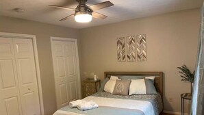 A bedroom with a bed, a ceiling fan, and two doors. - License To Chill - Lakefront/Screened in Porch (Bumpass)