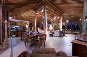 Cozy space with a dining area, seating area, and wooden beam structure.