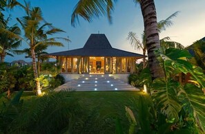 Set amidst lush tropical vegetation, this two-story building offers a serene atmosphere with large windows and a well-maintained lawn.