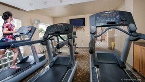 A gym with treadmills, a TV, and a fan. - Prime location, 5 minutes to the Beach, UCSD, Hospitals, UTC Mall  (San Diego)