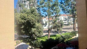 A view of a building with multiple floors, surrounded by trees and a grassy area. - Prime location, 5 minutes to the Beach, UCSD, Hospitals, UTC Mall  (San Diego)