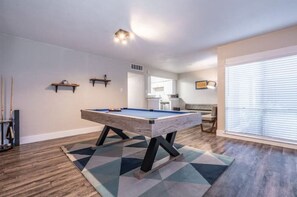 Relax in this stylish living room featuring a pool table and comfortable seating area.
