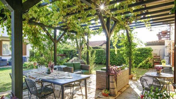 An outdoor patio with a pergola covered in grapevines, stone flooring, and outdoor furniture. - Stunning home in Cividale del Friuli (Cividale del Friuli)