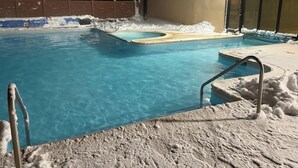 A swimming pool with a hot tub, surrounded by snow and a brick wall. - Ski In/out, Sleeps 8, Pool, Hot Tub, Snow Tubing! (Snowshoe)