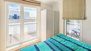 A bedroom with a bed, a wardrobe, and a window with blinds. - Beautiful home in Tossens with sauna (Tossens)