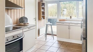 A kitchen with a built-in oven, a countertop with a decorative bowl, and a window with a view of the outdoors. - Awesome home in Sydals with kitchen (Sydals)