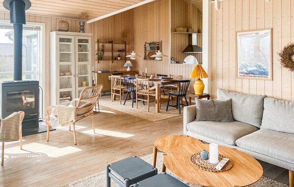 A cozy living room with a fireplace, a dining area with wooden furniture, and a kitchen with wooden cabinets.