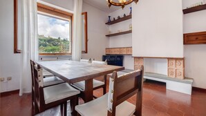 A dining area with a large table and chairs, a chandelier, and shelves with decorative items. - Cozy apartment in Recco with WiFi (Recco)