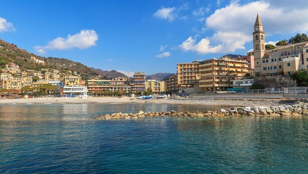 A coastal town with a prominent tower, colorful buildings, and a rocky shoreline. - Cozy apartment in Recco with WiFi (Recco)