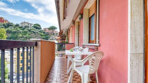 A balcony with a checkered floor, a white table, and two white chairs. - Cozy apartment in Recco with WiFi (Recco)