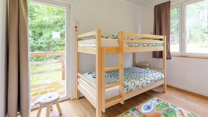 Dormitorio con literas y vistas al paisaje verde.