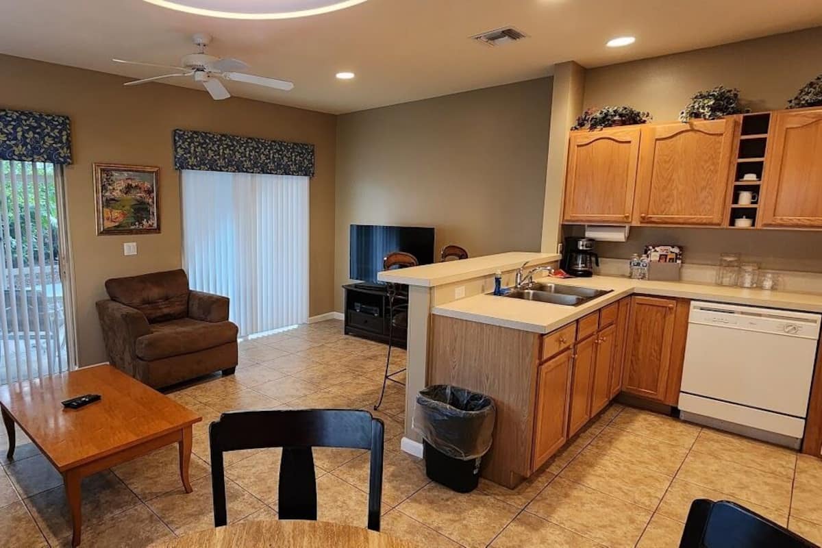 A compact living space with a sofa, dining table, and a kitchenette.