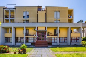 A multi-story building with a central entrance, balconies, and a small garden area. - GuestHost - Cozy and roomy apartment 93 sqm located on the first floor of a building WITHOUT a lift (stairs to access) can accommodate up to 6 people. The property, equipped with all the main comforts: bars, restaurants, supermarkets and pharmacy.The acc (Viareggio)