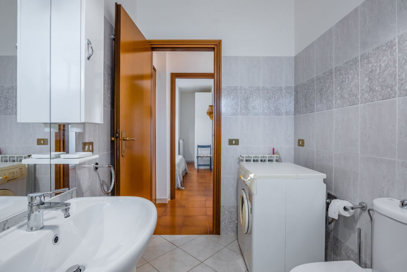 Une salle de bain avec un lavabo, un miroir et des toilettes.