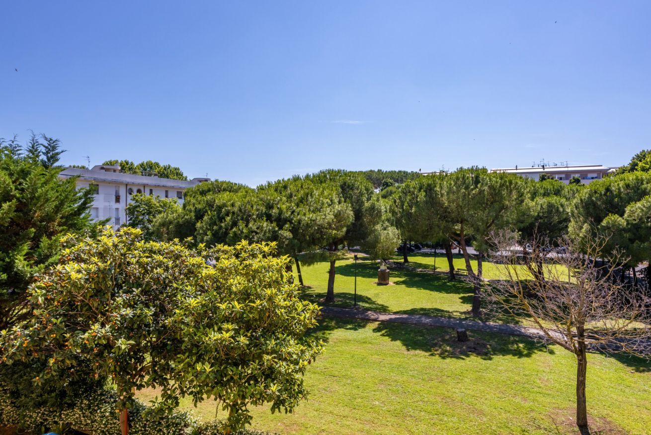A grassy area with trees and a building in the background.