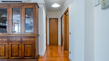 Un pasillo con un armario de madera, una puerta y una lámpara en el techo.