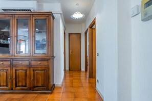 A hallway with a wooden cabinet, a door, and a ceiling light fixture. - GuestHost - Cozy and roomy apartment 93 sqm located on the first floor of a building WITHOUT a lift (stairs to access) can accommodate up to 6 people. The property, equipped with all the main comforts: bars, restaurants, supermarkets and pharmacy.The acc (Viareggio)
