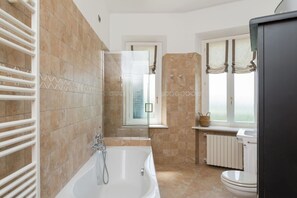 Tina con regadera, secadora de cabello, bidet, toallas 