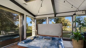 A hot tub area with a 'WELCOME' sign, large windows, and a view of the outdoors. - Indoor Pool & Hot Tub on Golf Course (Loveland)