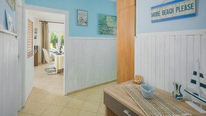 A hallway with a dining area, a sign reading "MORE BEACH PLEASE", and a view of the outdoors. - Lovely home in Visnjan (Visnjan)
