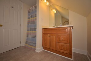 Bathroom features a spacious vanity with multiple drawers and a large mirror.