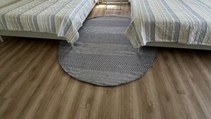 Ein Schlafzimmer mit zwei Betten, einem Fenster und einem kleinen Tisch.