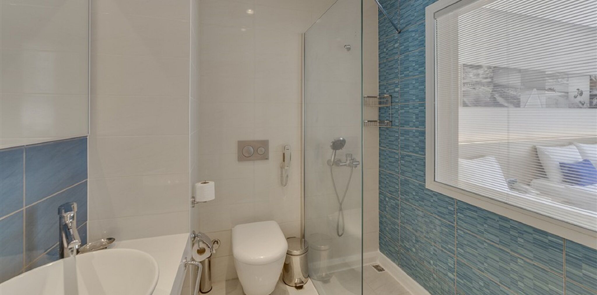 A modern bathroom with a glass shower enclosure, a toilet, and a sink.