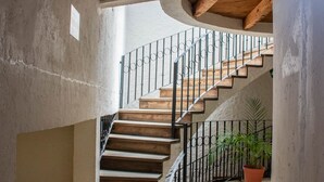 A staircase with wooden steps and black metal railings, leading to an upper floor. - Hotel Real del Carmen (San Cristóbal de las Casas)