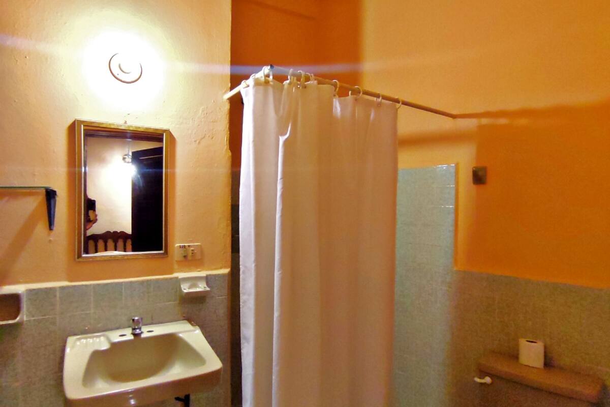 Une salle de bain équipée d’un lavabo, de toilettes et d’un rideau de douche.