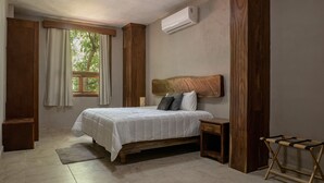Une chambre à coucher avec un lit en bois, une table de chevet, un banc en bois et une fenêtre avec des rideaux.