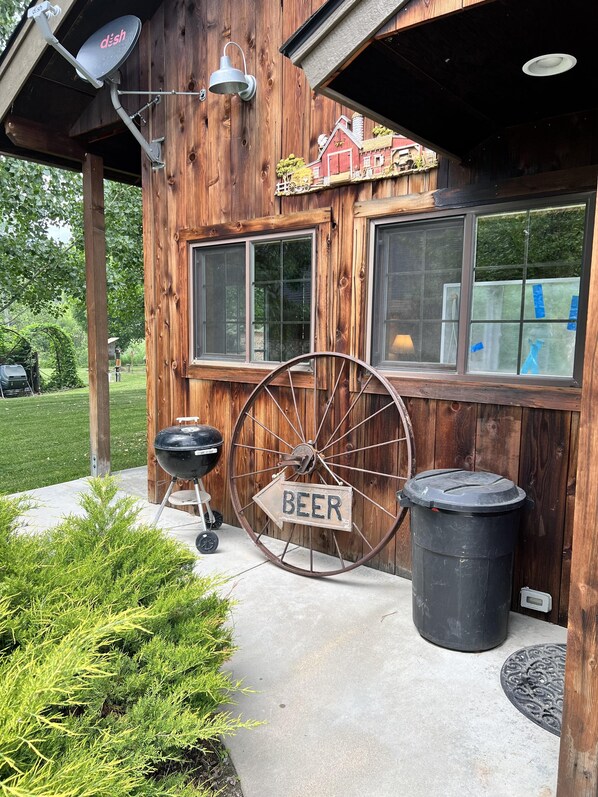 A rustic wooden building with a large wheel sign reading "BEER" and a small model train on the wall. - Escape to Nature in This Cozy Riverfront Cabin (Garden Valley)