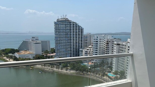 A balcony with a view of a marina and high-rise buildings.