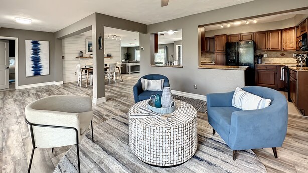 A spacious living room with a ceiling fan, a dining area, and a kitchen. - Relaxing Vacation Home on Water Next To Siesta Key (Sarasota)