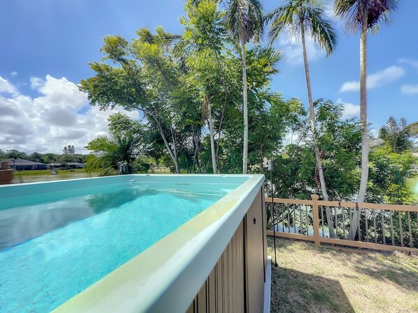 A swimming pool with a wooden deck and a wooden fence. - Relaxing Vacation Home on Water (Sarasota)