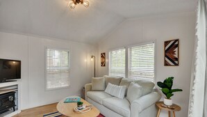 Un salon avec un canapé, une table basse, une cheminée et un téléviseur.