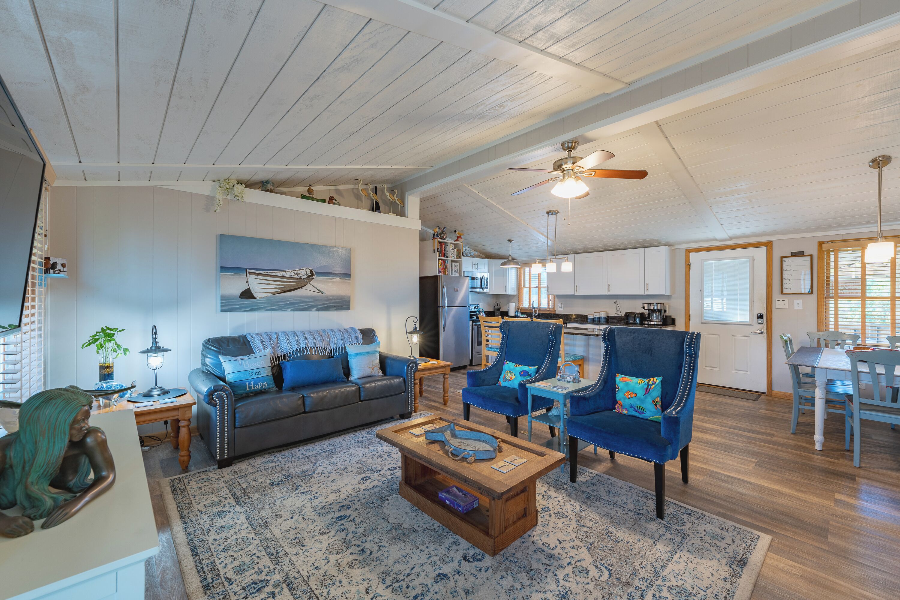 A spacious living area with a sofa, chairs, a coffee table, and a dining table.