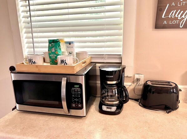 Eine Küche mit Edelstahl-Mikrowelle, Kaffeemaschine und Toaster auf der Arbeitsfläche.