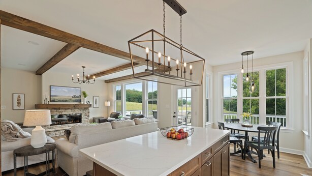 A spacious kitchen with a large island, wooden beams, and a stone fireplace. - NEW Luxury Cottage with Mountain Views (Stanley)