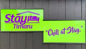 Two signs on a wooden wall. One sign reads "Stay at Timaru" with a house icon, and the other says "Chill at Stay." - Stay Timaru (Timaru)