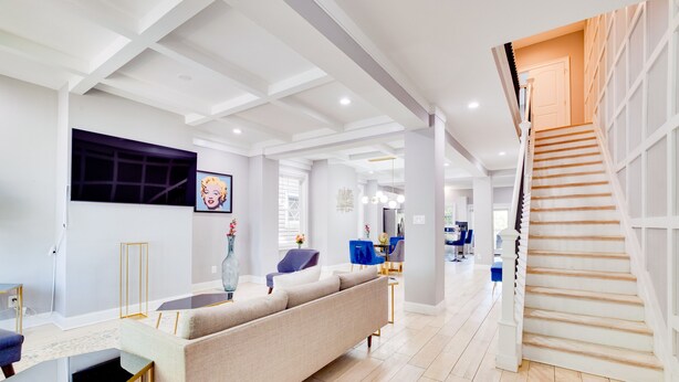 A modern living room with a sofa, a coffee table, and a staircase leading to another level.