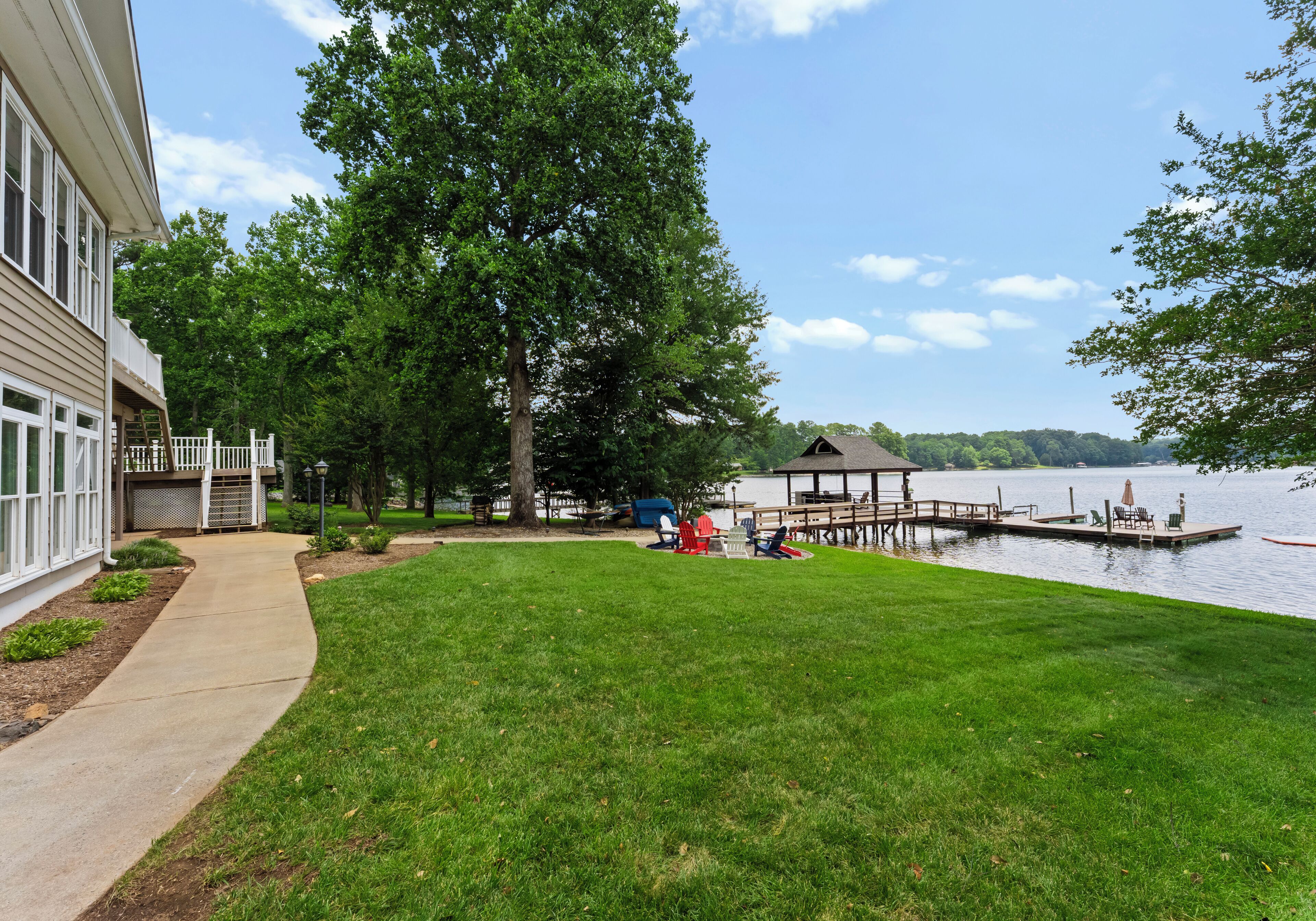 A lakeside property with a grassy lawn, a dock, and a gazebo.