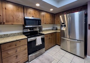 Enjoy cooking in this well-equipped kitchen with a refrigerator, microwave, double oven, and ample storage.