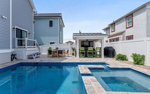 Ein Garten mit Schwimmbad, Gartenmöbeln und einer überdachten Terrasse.
