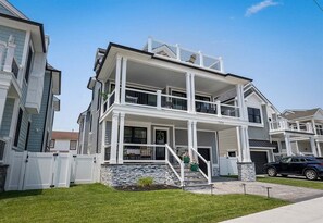 Ein zweistöckiges Wohngebäude mit Veranda, Treppe und Garage.