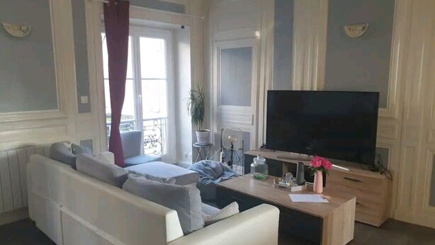 Una sala de estar con un sofá, una mesa de centro y un televisor.