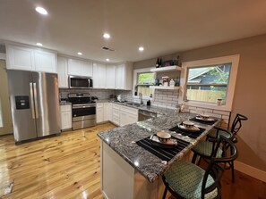 A modern kitchen with stainless steel appliances, white cabinets, and a granite countertop. - Farmhouse !! 1 min to Randy’s Icehouse, Tx Beer Co & Taylor Liquor & 5 Samsung (Taylor)